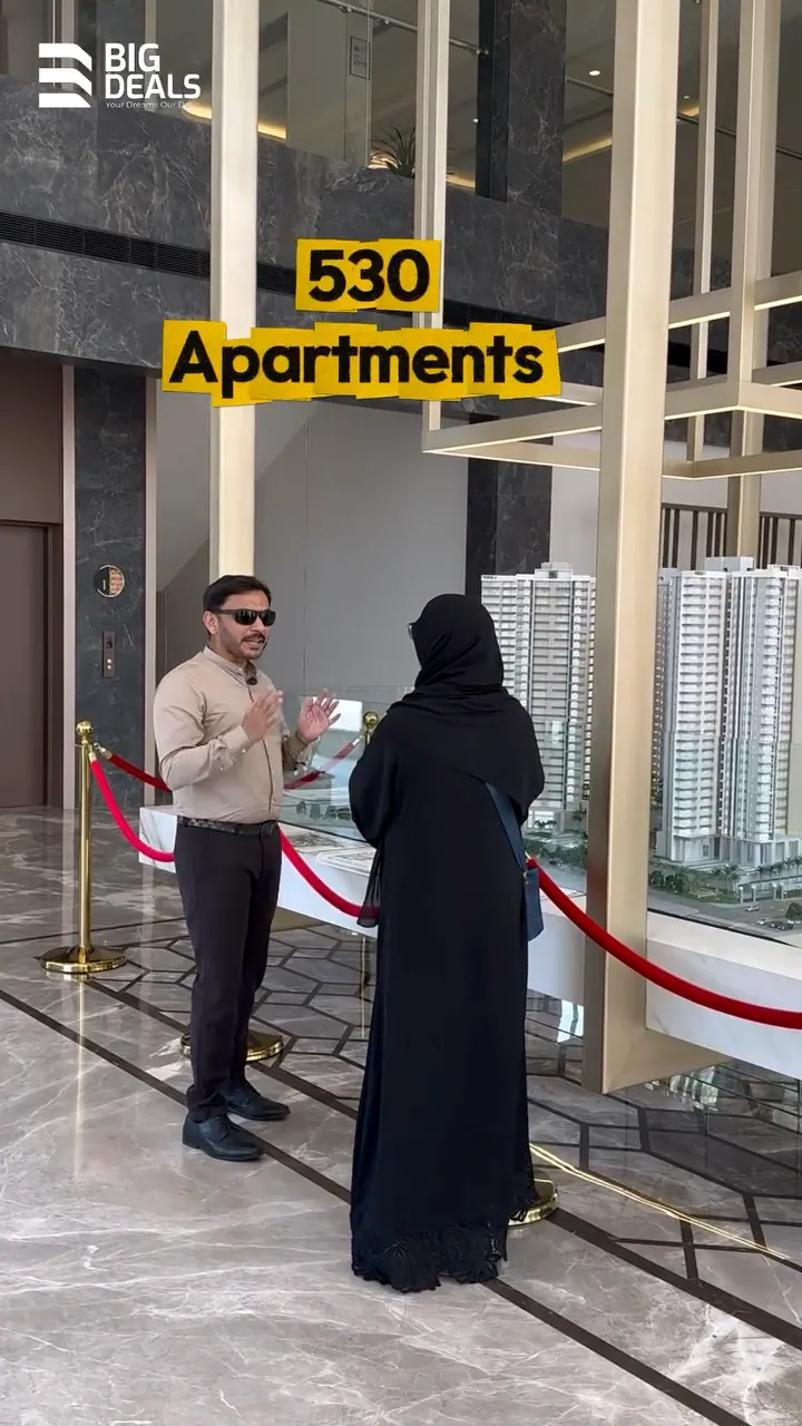 A presenter shows a visitor the scale model of Prestige Ocean Pearl's towers in its experience centre in Kozhikode, under the label 530 Apartments