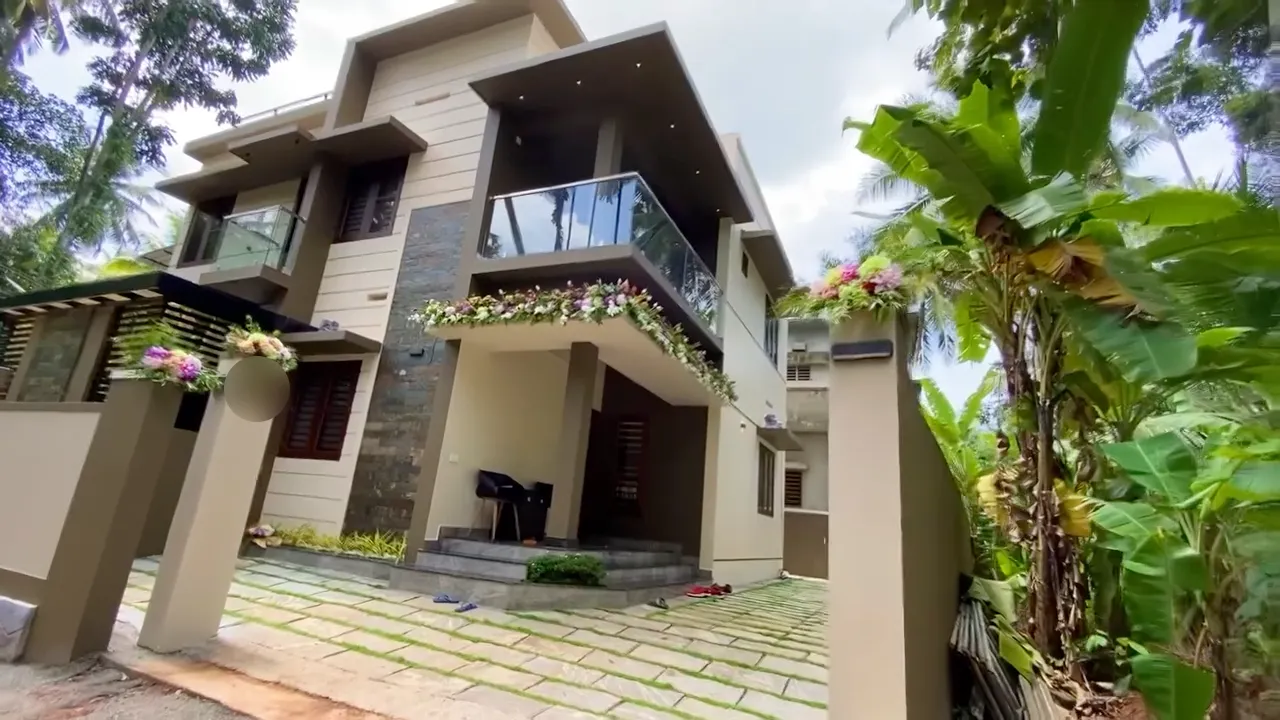 A new two-storey Hiline home with a glass balcony and stone cladding, dressed in flowers for its handover