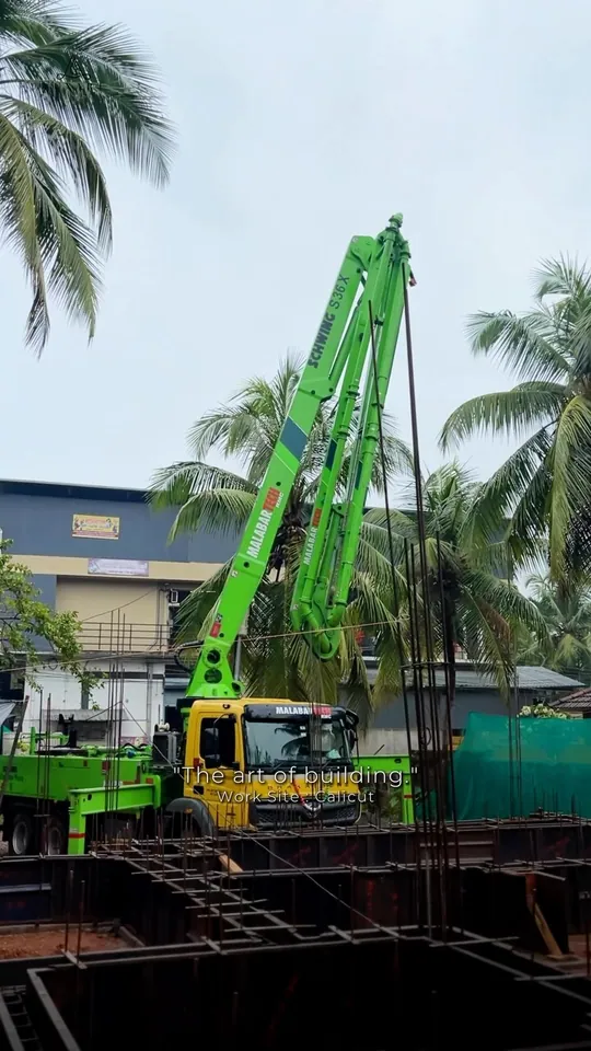 A green piling rig on a building site under coconut palms, on the cover of a Luxart Builders reel
