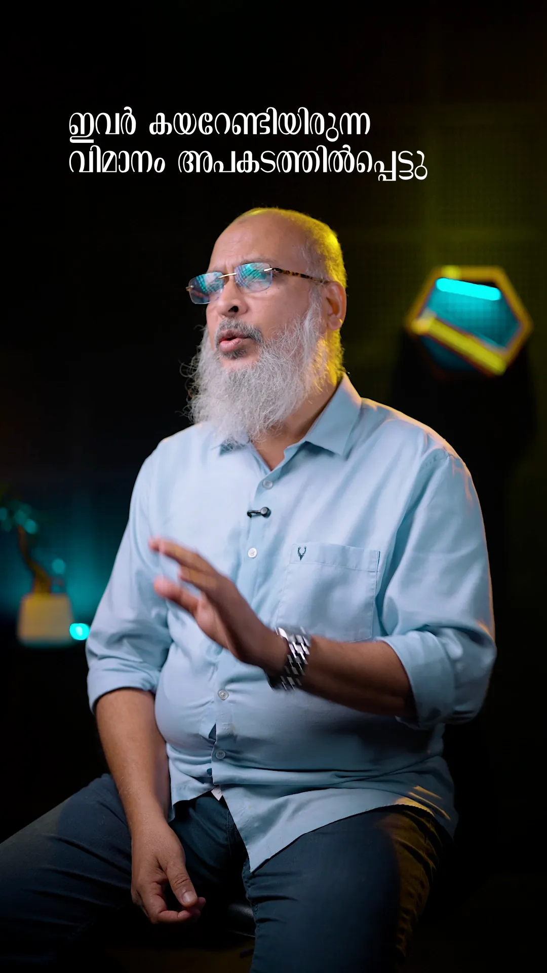 A frame from a presenter reel: an adult presenter on a dark studio set with a Malayalam caption