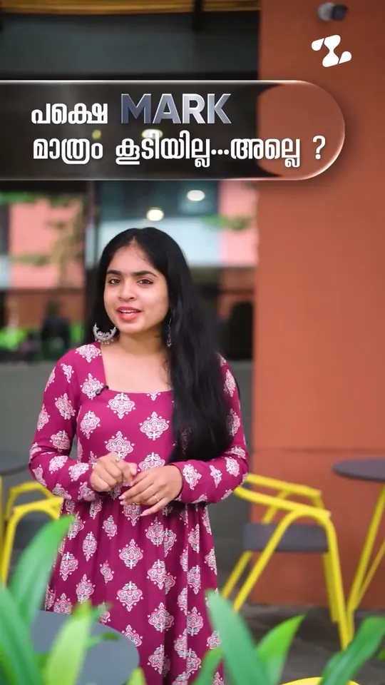 Presenter in a magenta printed kurta in a café courtyard, with a Malayalam caption saying the marks just didn't go up, in a Zealous Learning reel